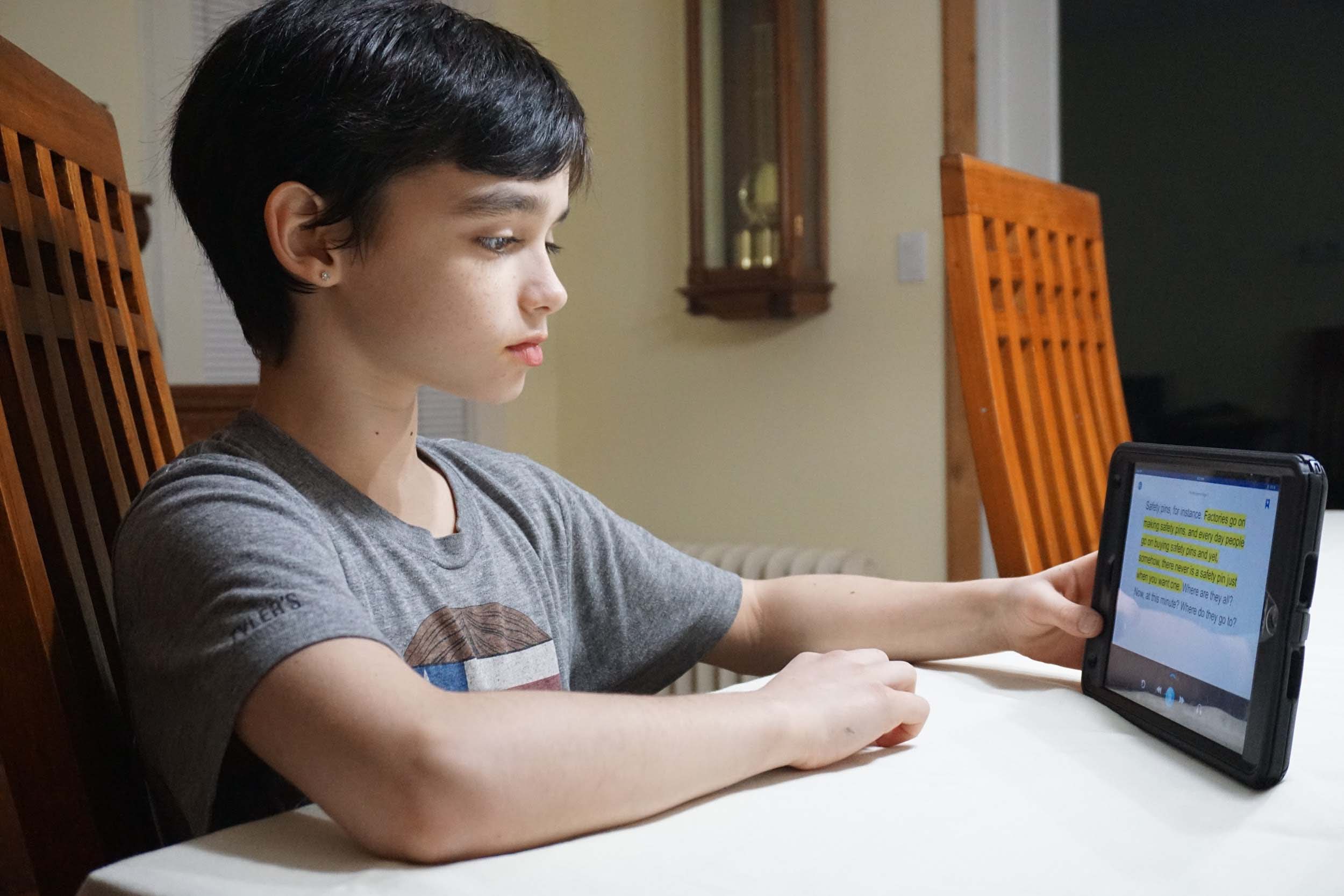 Boy Reads Using Device