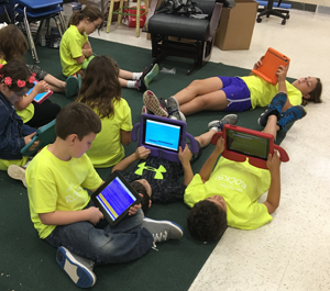 students reading with devices in classroom